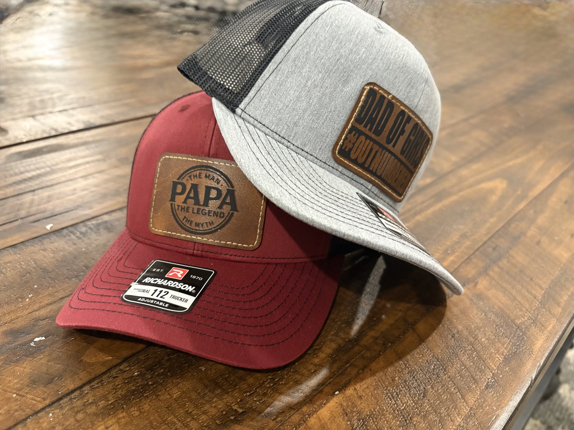 "Dad of Girls #OUTNUMBERED" on Rustic Leather Patch Trucker Hat