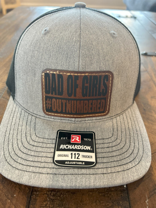 "Dad of Girls #OUTNUMBERED" on Rustic Leather Patch Trucker Hat